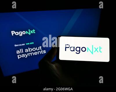 Personne tenant un smartphone avec le logo de la société espagnole de services financiers PagoNxt sur l'écran devant le site Web. Mise au point sur l'affichage du téléphone. Banque D'Images