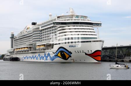 01 juin 2021, Mecklembourg-Poméranie occidentale, Warnemünde: L'Aidaprima a amarré au terminal de croisière sans passagers. Le navire doit être préparé pour son premier voyage après la crise de Corona à Warnemünde dans les semaines à venir. L'Aidaprima part de Kiel pour des croisières de sept jours à partir de 10.07.2021. Le nouveau départ de la croisière à Warnemünde est prévu par la compagnie de navigation Aida Cruises pour 01.07.2021 avec le 'AIDAsol'. Photo: Bernd Wüstneck/dpa-Zentralbild/dpa Banque D'Images