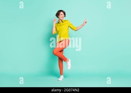 Photo de la taille du corps de la danse pleine de joie fille portant des vêtements décontractés isolé teal vif fond de couleur Banque D'Images