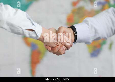 Les gens d'affaires se handshake sur le fond de la carte du monde Banque D'Images