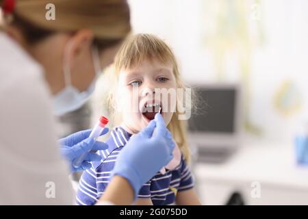 Le médecin prend le matériel biologique de la bouche avec un coton-tige Banque D'Images