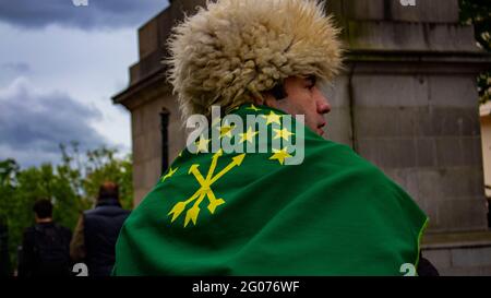 Londres, Royaume-Uni - 23 mai 2021: Un Circassien porte un chapeau et un drapeau traditionnels pour sensibiliser le public au génocide circassien. Banque D'Images