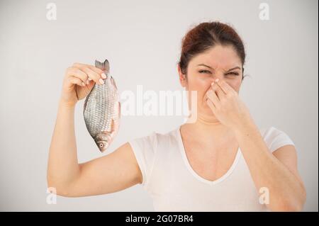 La femme caucasienne s'oppose à l'odeur dégoûtante du poisson. Une