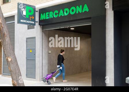 Une femme portant un masque facial par mesure de précaution contre la propagation du covid-19 entre dans un supermarché Mercadona. Banque D'Images