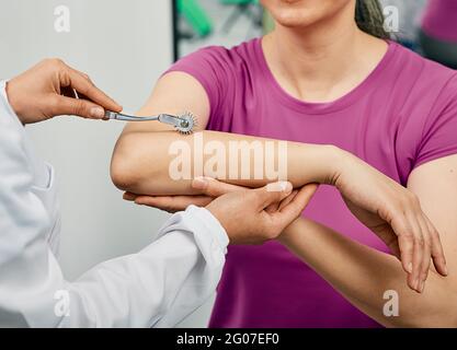 Neurologie. Vérifier la main de la femme en utilisant la roue d'aiguille neurologique dans une clinique neurologique, gros plan Banque D'Images