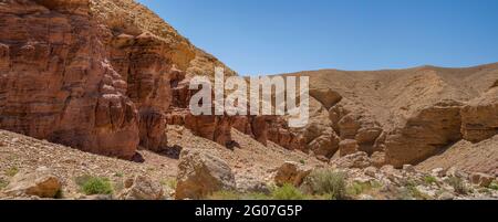 Roches sédimentaires rouges à côté des formations de calcaire dans le Red Canyon, près d'Eilat, en Israël, par une journée claire et ensoleillée. Banque D'Images