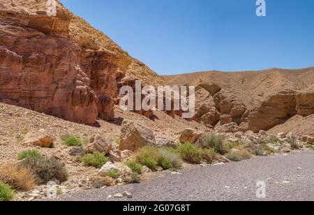 Roches sédimentaires rouges à côté des formations de calcaire dans le Red Canyon, près d'Eilat, en Israël, par une journée claire et ensoleillée. Banque D'Images