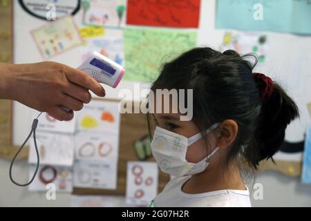 Ankara, Turquie. 1er juin 2021. La température d'un enfant est vérifiée à la maternelle d'Ankara, en Turquie, le 1er juin 2021. La Turquie est entrée dans une nouvelle phase mardi dans la lutte contre le COVID-19 après que le gouvernement ait encore assoupli les restrictions anti-coronavirus. Le verrouillage du week-end a été levé le samedi, et les couvre-feux nocturnes en semaine ont été reportés d'une heure. Les restaurants, les cafés et les installations sportives sont également devenus opérationnels avec un nombre limité de clients. Crédit: Mustafa Kaya/Xinhua/Alamy Live News Banque D'Images