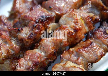 Shashlik ou shish kebab préparation sur barbecue grill sur charbon chaud. Morceaux de viande de porc grillés sur brochettes de métal. Banque D'Images