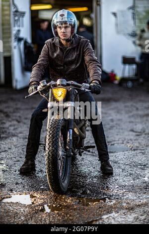 Jeune homme beau cycliste se préparant à monter.Portrait de beau jeune homme sur moto portant un casque . Banque D'Images