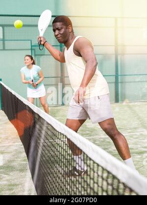 Sportif homme émotionnel jouant double paddle-tennis Banque D'Images