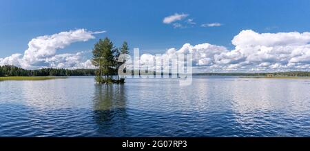 Grande vue panoramique en été calme lac dans le nord de la Suède avec très petite île avec peu d'arbres. Chaud ensoleillé jour d'été, nuages blancs sur ciel bleu, peu Banque D'Images