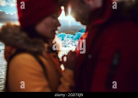 Vue latérale des jeunes hommes et femmes en hiver porter debout près de l'eau avec de la glace Banque D'Images