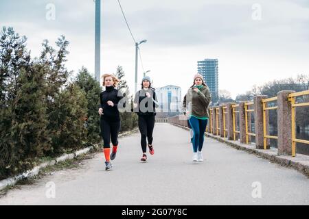 Groupe de jeunes sportifs et d'âge moyen courant dans l'environnement urbain. Groupe de coureurs dans le parc à l'automne automne matin de printemps. Groupe de Banque D'Images