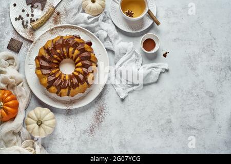 Du haut de la composition du petit déjeuner d'automne avec cruller rond maison avec tasse de garniture au chocolat de boisson chaude et de petits citrouilles arrière-plan blanc Banque D'Images