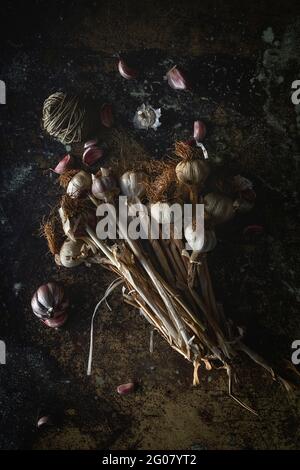 Du dessus bouquet de gousses d'ail violet frais placées dans arrière-plan sombre Banque D'Images