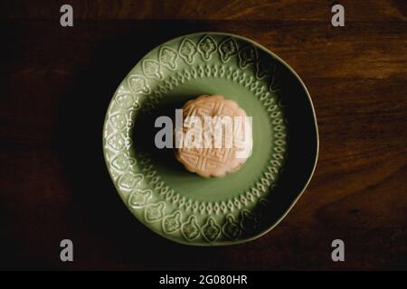 Assiette décorative avec gâteau de riz gluant placée sur le plan d'examen de bois dans le café Banque D'Images