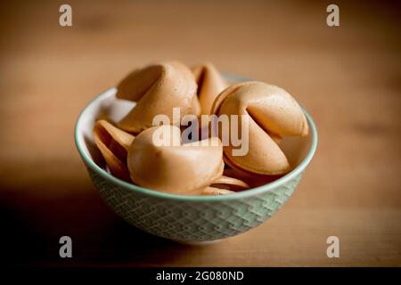 Gros plan petit bol rempli de biscuits croustillants fortune table en bois Banque D'Images
