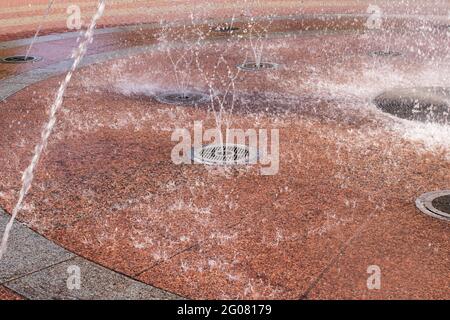 Fontaine éclabousse sur le fond rouge des carreaux Banque D'Images