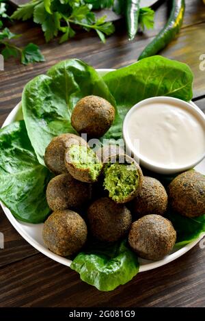 Boules de falafel. Boules frites de pois chiches moulus. Cuisine traditionnelle du Moyen-Orient. Arrière-plan en bois, vue rapprochée Banque D'Images