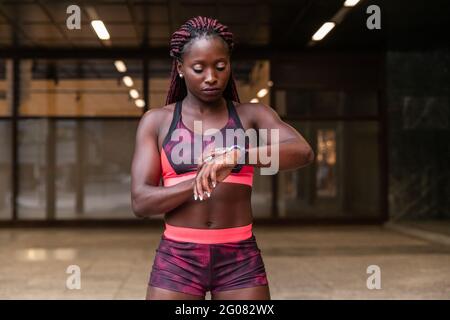 Jeune sportif ethnique musclé qui se réveille à l'heure tout en s'faisant de l'sport dans la rue Banque D'Images