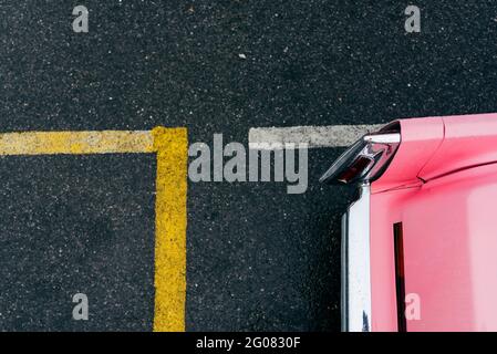 Vue de dessus du détail de mise au point arrière d'un rose classique voiture sur un sol en asphalte Banque D'Images