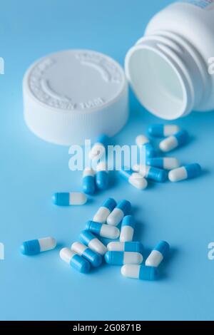 Capsules de pilule bleue et blanche étalée sur fond bleu avec ombre . Concept global de soins de santé. Résistance aux antibiotiques. Capsule antimicrobienne pil Banque D'Images