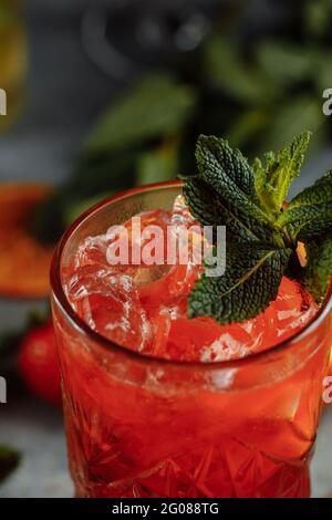 Boissons rafraîchissantes colorées pour l'été, jus de limonade froid aux fraises avec glaçons dans les verres garnis de tranches de citrons frais Banque D'Images