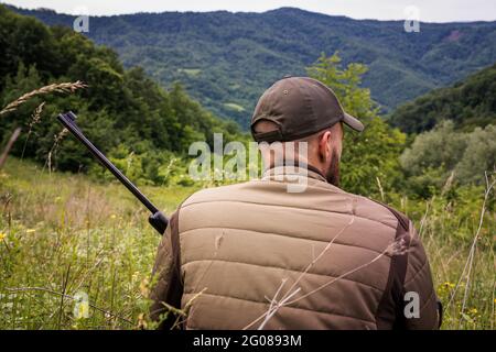 Un chasseur attend patiemment avec son fusil Banque D'Images