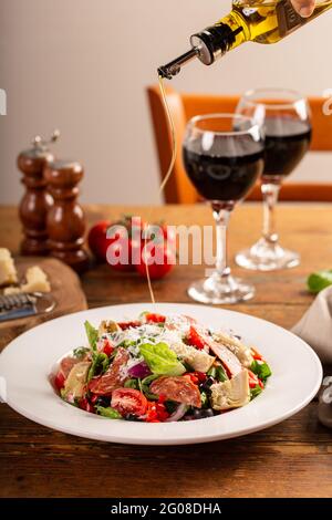 Salade d'antipasti italiens avec salami, cœurs d'artichaut et olives Banque D'Images