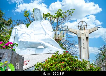 Statue de Marie tenant le Seigneur Jésus avec les bras débordés en arrière-plan sur le Mont Nho attire les touristes à visiter et adorer à Vung Tau Banque D'Images