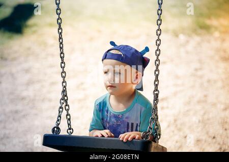 Portrait d'un petit garçon jouant avec balançoire au parc Banque D'Images