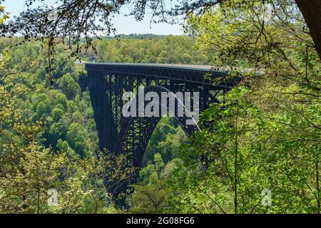 Arche centrale du pont New River gorge, vue entre le feuillage du début du printemps Banque D'Images