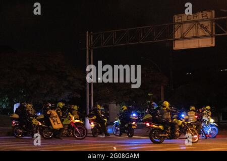 Medellin, Colombie, le 31 mai 2021. La police anti-émeute de Colombie arrive dans des motocycles à la manifestation alors qu'un groupe de manifestants à capuchon se heurte à la police anti-émeute de Colombie (ESMAD) à Medellin, Colombie lors des manifestations anti-gouvernementales en cours contre la réforme fiscale et sanitaire du président Ivan Duque et les brutalités et troubles de la police qui ont fait au moins 70 morts au cours du mois dernier, à Medellin, en Colombie, le 31 mai 2021. Banque D'Images