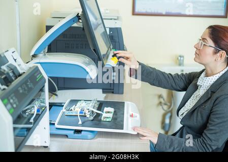 Woman examine les microcircuits sur un appareil spécial pour la lecture des malvoyants. Banque D'Images