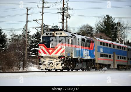 Genève, Illinois, États-Unis. Une locomotive Metra à la croûte de glace conduit un train de banlieue de Chicago à travers la neige et Genève, Illinois. Banque D'Images