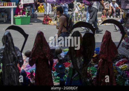 Un fidèle tient une statue de Santa Muerte, en arrivant à l'autel de Santa Muerte dans la ville de Tepito, dans le cadre des célébrations qui ont eu lieu le premier jour de chaque mois, des centaines de dévotés assistent à la vénération, remerciez pour les faveurs et les promesses tenues que cette déité leur a accordées. La Santa Muerte ou Santisima Muerte est une figure mexicaine populaire qui personnifie la mort et est un objet de culte, les dévotés d'elle sont généralement perçus comme des personnes associées à la criminalité, l'activité des gangs, la prostitution, le trafic de drogue. Mexico, Mexique, 1er juin 2021. Photo de Ricardo Banque D'Images