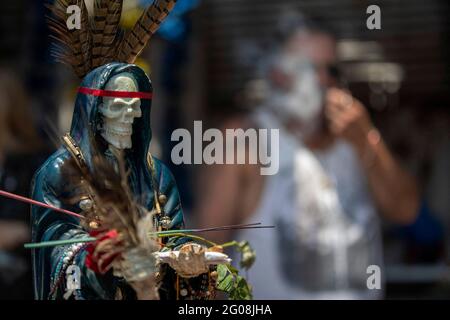 Un fidèle tient une statue de Santa Muerte, en arrivant à l'autel de Santa Muerte dans la ville de Tepito, dans le cadre des célébrations qui ont eu lieu le premier jour de chaque mois, des centaines de dévotés assistent à la vénération, remerciez pour les faveurs et les promesses tenues que cette déité leur a accordées. La Santa Muerte ou Santisima Muerte est une figure mexicaine populaire qui personnifie la mort et est un objet de culte, les dévotés d'elle sont généralement perçus comme des personnes associées à la criminalité, l'activité des gangs, la prostitution, le trafic de drogue. Mexico, Mexique, 1er juin 2021. Photo de Ricardo Banque D'Images