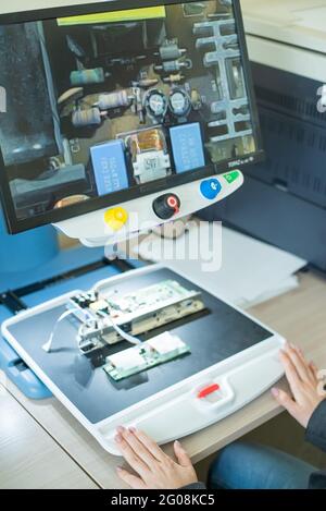 Woman examine les microcircuits sur un appareil spécial pour la lecture des malvoyants. Banque D'Images