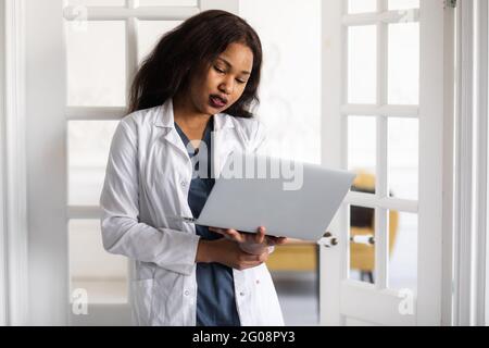 Un beau médecin afro-américain s'est contenté de travailler sur un ordinateur portable. Télémédecine Banque D'Images