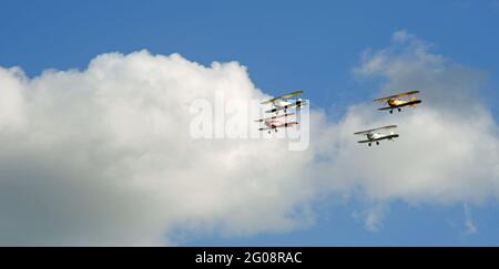 Vintage Tiger Moth Bi planes voler en formation bleu ciel et nuages. Banque D'Images