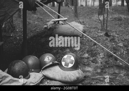 Casques métalliques du soldat d'infanterie de l'armée des États-Unis à la Seconde Guerre mondiale Casques près de la tente de camping dans Forest Camp. Photographie en noir et blanc. Banque D'Images