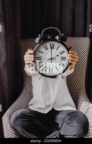 Femme d'affaires couvrant son visage avec une horloge analogique vintage Banque D'Images