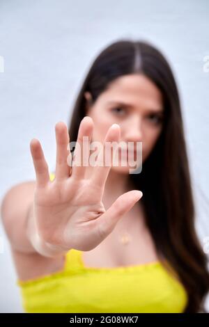 Gros plan d'une jeune femme qui fait preuve d'un geste d'arrêt et qui dit à la main non à la violence familiale ou à l'abus, protestation féminine contre l'avortement ou la discrimination, concept de langage non verbal. Photo de haute qualité. Banque D'Images