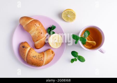 Thé vert avec citron et menthe dans une tasse en verre. Thé avec de riches bagels Banque D'Images