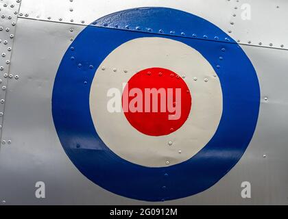 Grand symbole de cible RAF rétro sur un ancien avion abandonné. Fuselage en métal argenté avec rivets sur un avion de chasse désaffecté historique de la Seconde Guerre mondiale Banque D'Images