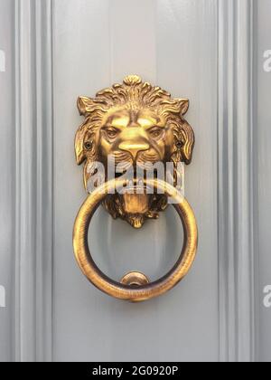 Porte-perce à tête de lion d'or avec l'anneau sur sa bouche à l'entrée d'une maison, Malte. Poignée de porte traditionnelle italienne. Ancienne poignée de porte en métal ornée. Banque D'Images