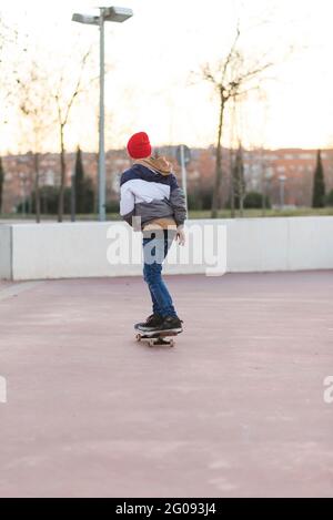 Adolescent skateboarder garçon avec une planche à roulettes sur l'asphalte terrain de jeu faire des tours. Génération de jeunes image de concept de temps libre. Banque D'Images