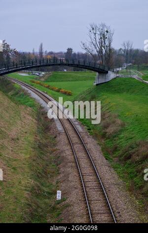 Petite passerelle au-dessus de la voie ferrée lors d'une journée d'automne nuageux. Rails près de la ville polonaise de Zamosc. Banque D'Images