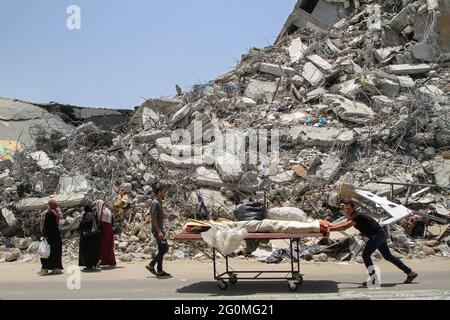 Gaza. 1er juin 2021. Un travailleur palestinien enlève les décombres d'un bâtiment détruit par des frappes aériennes israéliennes dans la ville de Gaza le 1er juin 2021. Naji Sarhan, sous-secrétaire du ministère des travaux publics et du logement de la bande de Gaza, dirigé par le Hamas, a déclaré à Xinhua que le bombardement israélien de l'enclave côtière avait détruit les infrastructures, y compris les bâtiments résidentiels, les usines et les hôpitaux. On estime que 1,100 logements ont été complètement détruits et que 900 autres ont été partiellement détruits et rendus inhabitables. Credit: Rizek Abdeljawad/Xinhua/Alamy Live News Banque D'Images